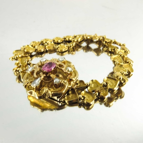 130 - A Victorian gold, diamond and ruby bracelet, the cast heart linked double chain band with foliate sc... 