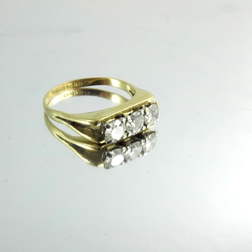 150 - An 18 carat gold and three stone diamond ring, channel claw set, approx size L