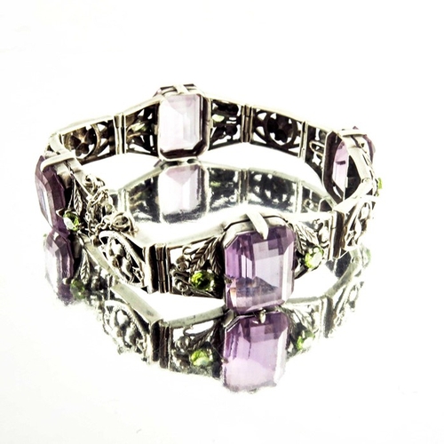 163 - Sybil Dunlop, an Arts and Crafts silver, amethyst and peridot bracelet, emeral cut purple stones in ... 