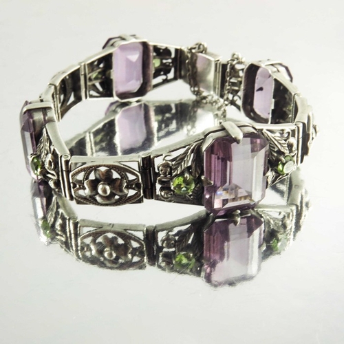 163 - Sybil Dunlop, an Arts and Crafts silver, amethyst and peridot bracelet, emeral cut purple stones in ... 