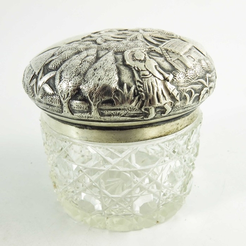 19 - A 19th century Oriental white metal lidded cut glass jar, repousse decorated and etched with village... 