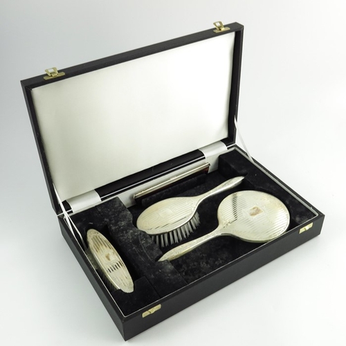 51 - An Elizabeth II silver backed dressing set, W I Broadway and Co., Birmingham 1992, engine turned str... 