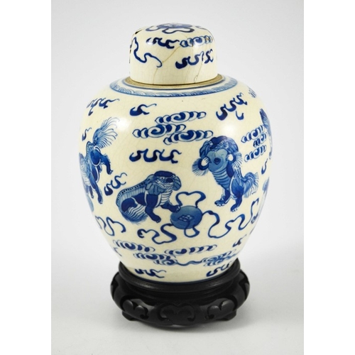 388 - A Chinese blue and white ginger jar and cover, Kangxi mark, painted with dogs in clouds, on a hardwo... 