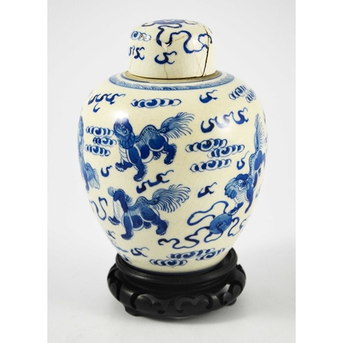 388 - A Chinese blue and white ginger jar and cover, Kangxi mark, painted with dogs in clouds, on a hardwo... 