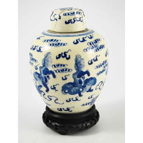 388 - A Chinese blue and white ginger jar and cover, Kangxi mark, painted with dogs in clouds, on a hardwo... 