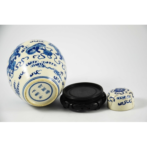 388 - A Chinese blue and white ginger jar and cover, Kangxi mark, painted with dogs in clouds, on a hardwo... 