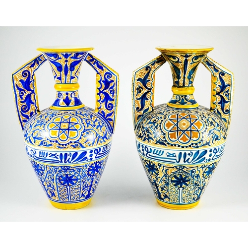 400 - A Near Pair of Middle Eastern Glazed Ceramic two handled ewers, decorated in cobalt blue and ochre c... 