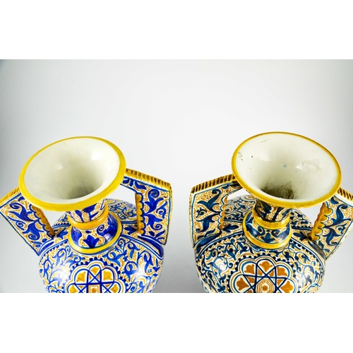 400 - A Near Pair of Middle Eastern Glazed Ceramic two handled ewers, decorated in cobalt blue and ochre c... 