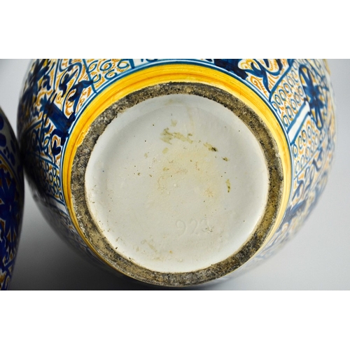 400 - A Near Pair of Middle Eastern Glazed Ceramic two handled ewers, decorated in cobalt blue and ochre c... 