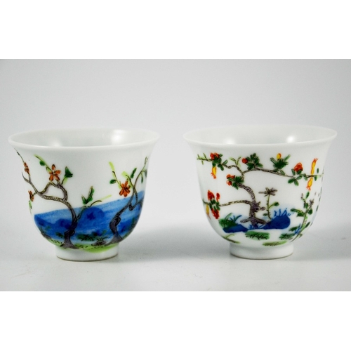 418 - A pair of Chinese Doucai cups or tea bowls, Kangxi marks, footed bell form, painted with prunus and ... 