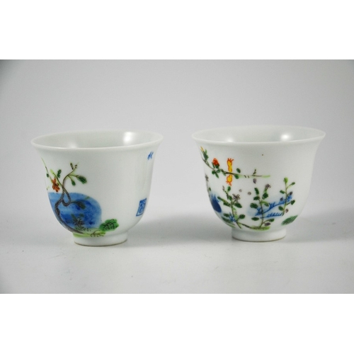 418 - A pair of Chinese Doucai cups or tea bowls, Kangxi marks, footed bell form, painted with prunus and ... 