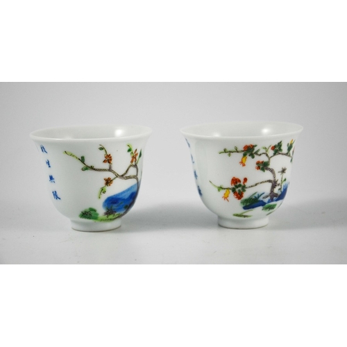 418 - A pair of Chinese Doucai cups or tea bowls, Kangxi marks, footed bell form, painted with prunus and ... 