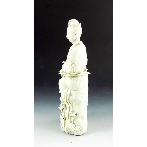 429 - A Chinese Porcelain Blanc de Chine Figurative Candlestick, the figure perched on a stylised tree stu... 