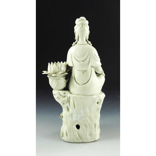 429 - A Chinese Porcelain Blanc de Chine Figurative Candlestick, the figure perched on a stylised tree stu... 