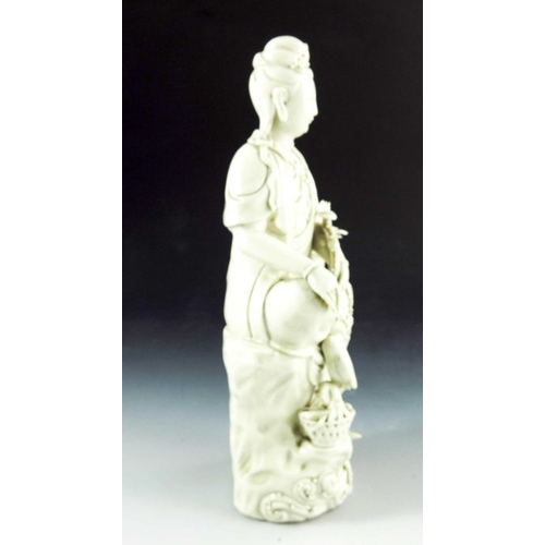 429 - A Chinese Porcelain Blanc de Chine Figurative Candlestick, the figure perched on a stylised tree stu... 