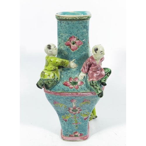 430b - An Oriental vase, square section lozenge form relief moulded with acrobatic boys, 22cm high