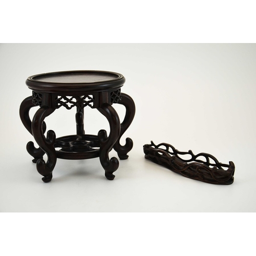 439 - Two Chinese carved hardwood stands, reticulated friezes, one with a five spoked wheel uniting S scro... 