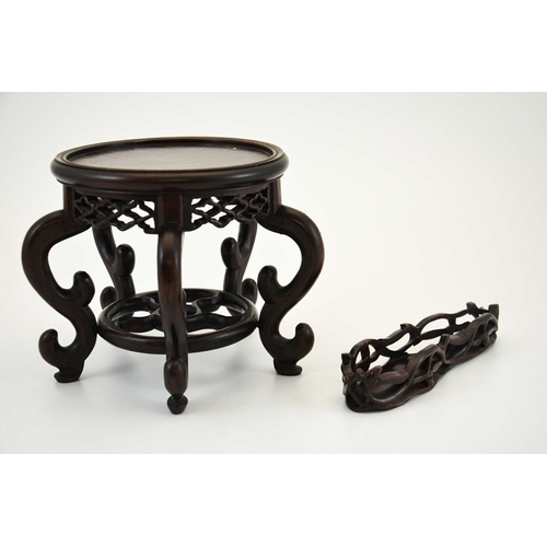 439 - Two Chinese carved hardwood stands, reticulated friezes, one with a five spoked wheel uniting S scro... 