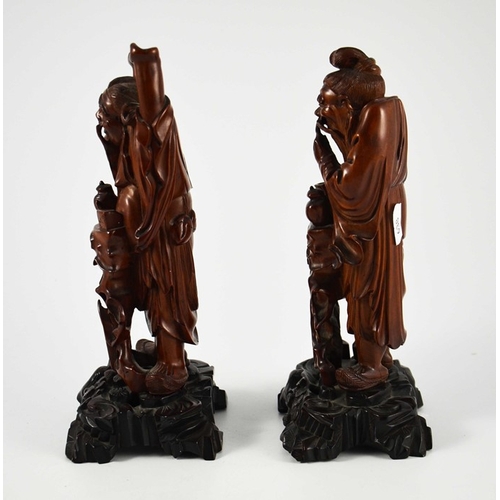 442 - A pair of Chinese carved hardwood figures, 19th century, modelled as old men with teapots, one takin... 