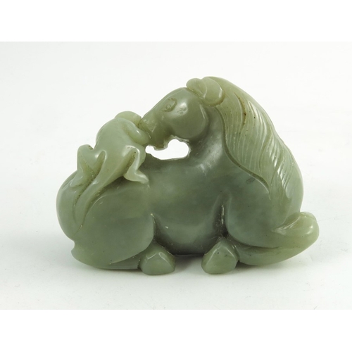 468 - A Chinese Jade Horse, the finely carved recumbent horse, its head turned back surveying a small monk... 