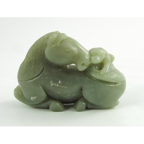 468 - A Chinese Jade Horse, the finely carved recumbent horse, its head turned back surveying a small monk... 