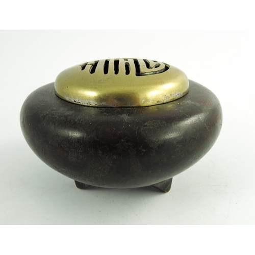 485 - A Chinese bronze censer, with a reticulated cover, three footed ovoid form, 11cm diameter, 507g