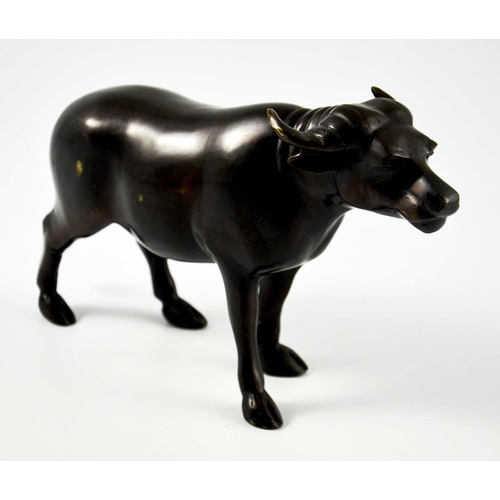 488 - An Oriental bronze figure of a water buffalo, modelled standing, 15cm high, 26cm long