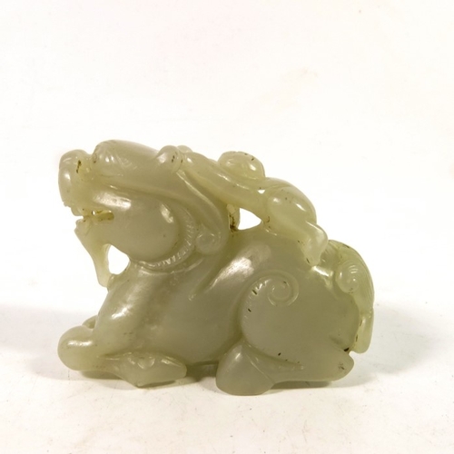 493 - A Chinese jade carving of a boy on the back of a dragon, 8cm