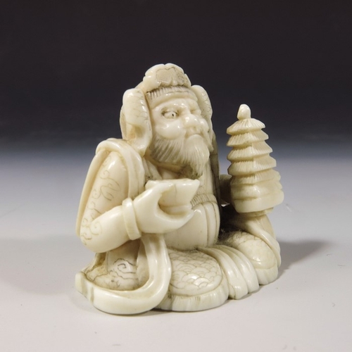 496 - λ A 19th century Japanese carved ivory okimono, Meiji, modelled as a sitting man with temple and bow... 