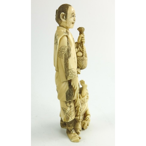 497 - λ A 19th century Japanese ivory okimono, Meiji, modelled as a father and son, 15cm high