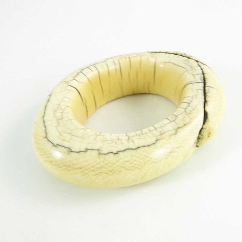 499 - An antique ivory tribal bangle, possibly West of Central African, circa 19th century, of oval form, ... 