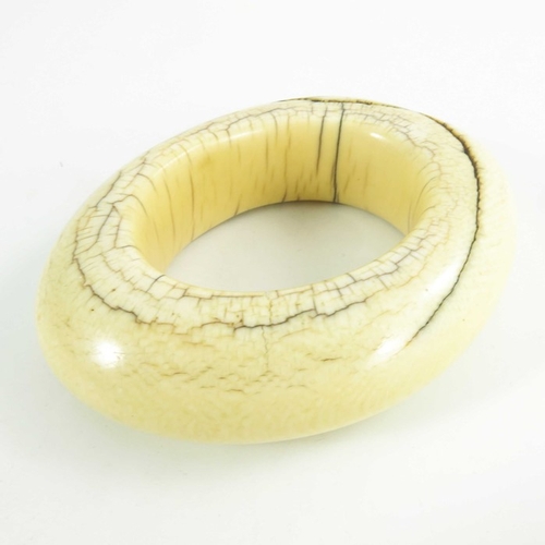 499 - An antique ivory tribal bangle, possibly West of Central African, circa 19th century, of oval form, ... 