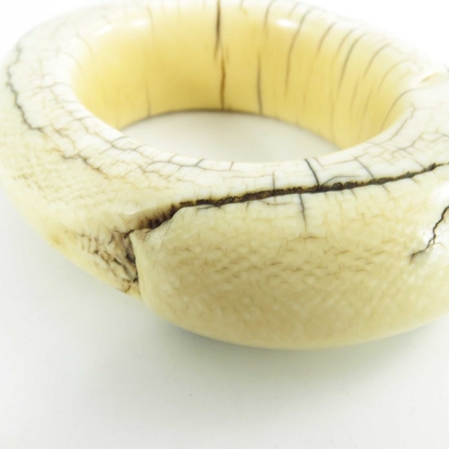 499 - An antique ivory tribal bangle, possibly West of Central African, circa 19th century, of oval form, ... 