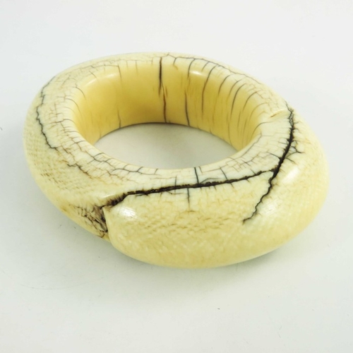 499 - An antique ivory tribal bangle, possibly West of Central African, circa 19th century, of oval form, ... 