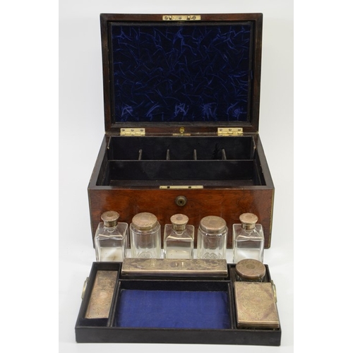 534 - A mid 19th century mahogany vanity case inlaid with brass edging, containing silver topped glass bot... 