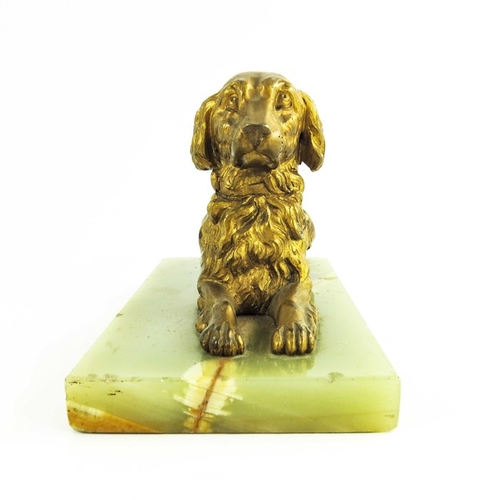 570 - A 19th century gilt bronze figure of a reclining spaniel on a onyx base, 12cm high including base