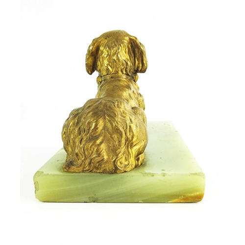 570 - A 19th century gilt bronze figure of a reclining spaniel on a onyx base, 12cm high including base