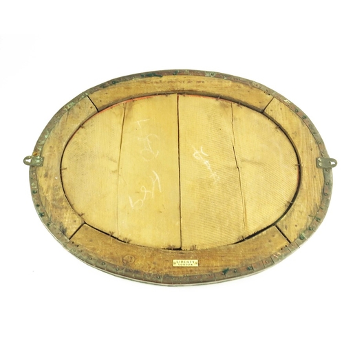 580 - Liberty and Co., an Arts and Crafts copper and Ruskin cabochon mirror, oval, planishe dand riveted w... 