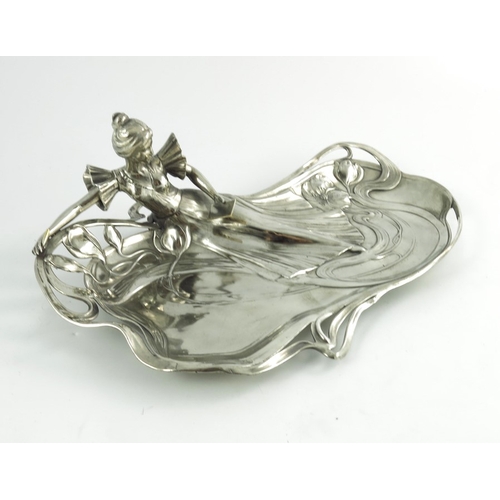 602 - WMF, a Jugendstil silver plated card tray, modelled in relief as a woman reading, reclining on an op... 