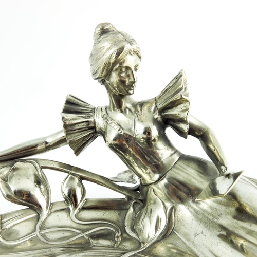 602 - WMF, a Jugendstil silver plated card tray, modelled in relief as a woman reading, reclining on an op... 