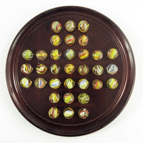 749 - A wooden solitaire board with 33 swirl marbles in 'English' colours, including solid cores, board 22... 