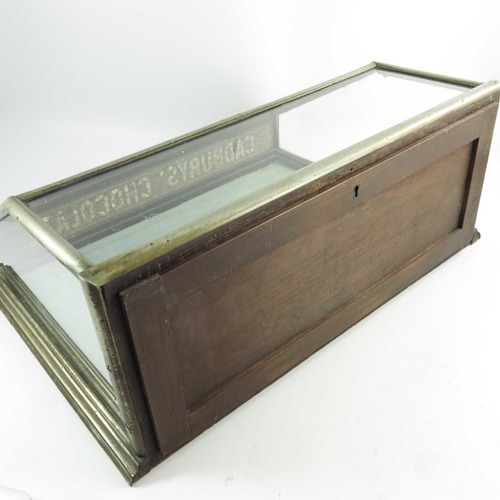 755 - A shop display cabinet for Cadbury's Chocolate, in a metal plated mahogany frame with sloping glass ... 