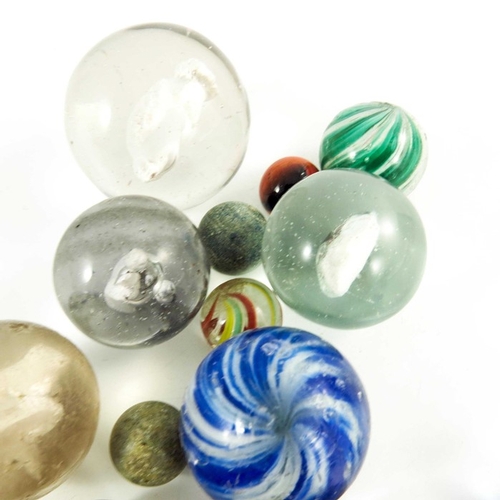 784 - A box containing four Sulphide and other Victorian glass and stone marbles, 12mm to 44 mm