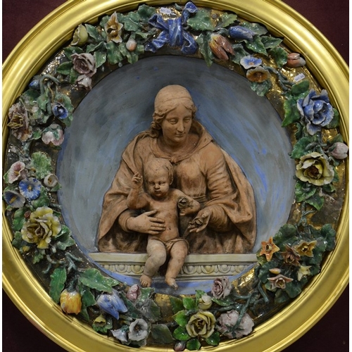 1006 - A Della Robbia plaque in a glass case, Italian 19th century, gilded frame, mounted on board, plaque ... 