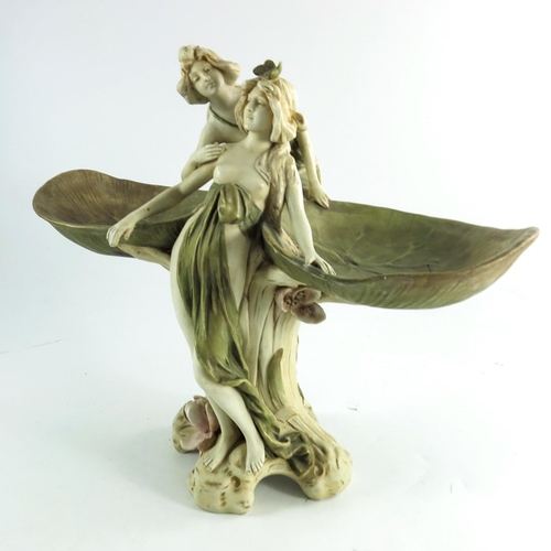 1009 - A Royal Dux figure group, circa 1920, modelled as two wood nymphs partially dressed climbing on a pl... 