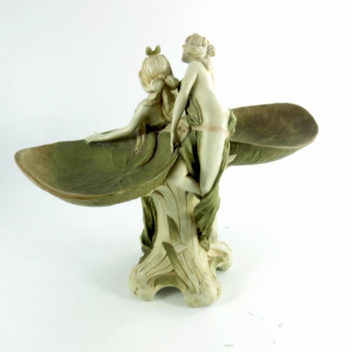 1009 - A Royal Dux figure group, circa 1920, modelled as two wood nymphs partially dressed climbing on a pl... 