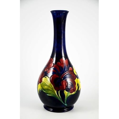 1087 - Walter Moorcroft, a Hibiscus vase, circa 1960s, elongated neck baluster form, on blue, impressed mar... 