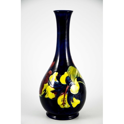 1087 - Walter Moorcroft, a Hibiscus vase, circa 1960s, elongated neck baluster form, on blue, impressed mar... 