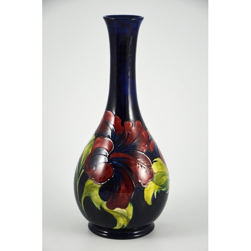 1087 - Walter Moorcroft, a Hibiscus vase, circa 1960s, elongated neck baluster form, on blue, impressed mar... 