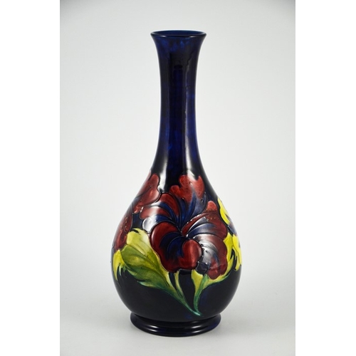 1087 - Walter Moorcroft, a Hibiscus vase, circa 1960s, elongated neck baluster form, on blue, impressed mar... 